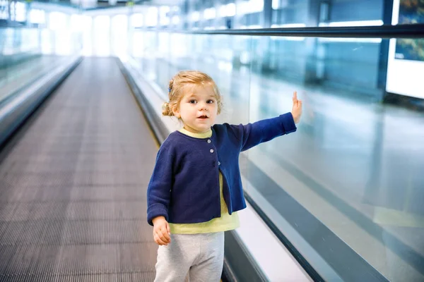 Uma menina adorável no aeroporto. Criança encantadora caminhando até o portão e saindo de férias em família de avião. Criança feliz positiva . — Fotografia de Stock