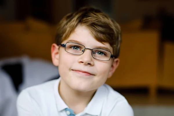 Πορτρέτο του μικρού χαριτωμένου σχολιαρόπαιδο με γυαλιά. Όμορφο χαρούμενο παιδί κοιτάζει την κάμερα. Ο μαθητής χαμογελάει. Εκπαιδευτική έννοια. — Φωτογραφία Αρχείου