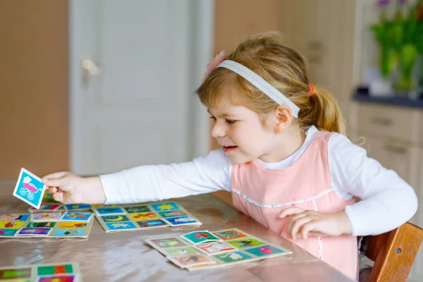 Adorável bonito menina criança jogando jogo de cartas de imagem. Memória de treinamento infantil saudável feliz, pensando. Criativa dentro de casa lazer e educação da criança durante a pandemia coronavírus doença de quarentena vívida — Fotografia de Stock