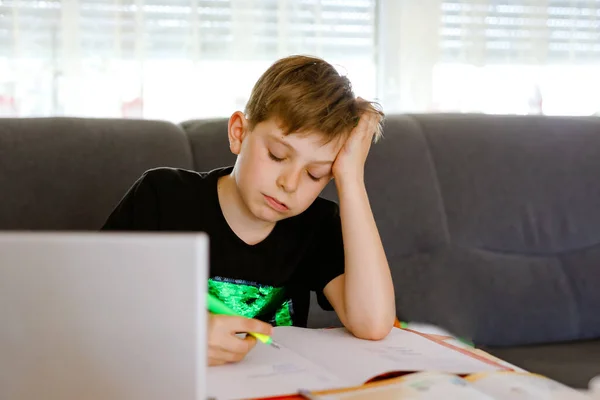 Corona salgınından dolayı karantina zamanında ödev yapan liseli çocuk. Hüsrana uğramış üzgün çocuk evde bilgisayarla video izlemeyi öğreniyor. Evde eğitim kavramı — Stok fotoğraf