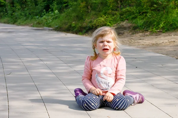 Mignon bouleversé malheureux tout-petit fille pleurer. Enfant émotionnel en colère criant. Portrait d'enfant avec des larmes. Fille assise sur le sol à pleurer — Photo