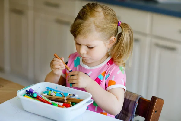 Kis csecsemő lány festmény különböző színes tollak és filctollak alatt pandémiás coronavírus karantén betegség. Gyermek egyedül otthon, zárt gyerekszoba — Stock Fotó