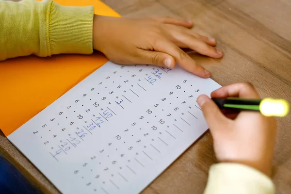 Criança escolar fazendo trabalhos de casa de matemática durante a quarentena da doença pandêmica de corona. prática infantil tabelas de multiplicação e matemática básica escrever com caneta, ficar em casa. Conceito de ensino em casa — Fotografia de Stock