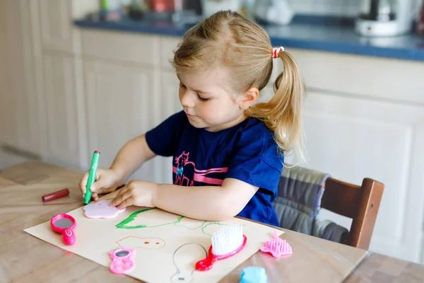 Pequena menina pintando com canetas de feltro durante a pandemia coronavírus quarentena doença. Criança criativa feliz, educação em casa e creche em casa com os pais — Fotografia de Stock