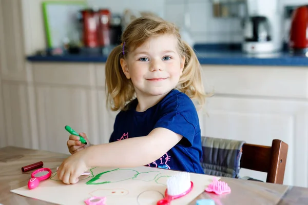 Pequeña niña pintando con plumas de fieltro durante la enfermedad pandémica de cuarentena por coronavirus. Feliz niño creativo, educación en casa y guardería en casa con los padres — Foto de Stock