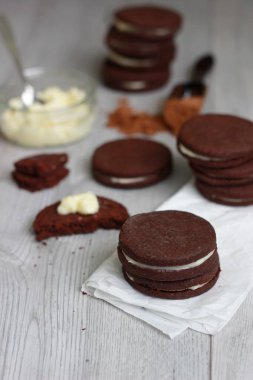 Çikolatalı sandviç çerezleri üzerinde ahşap arka plan doldurarak krema ile