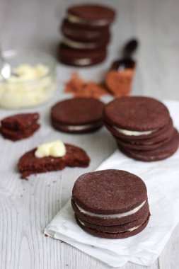 Çikolatalı sandviç çerezleri üzerinde ahşap arka plan doldurarak krema ile