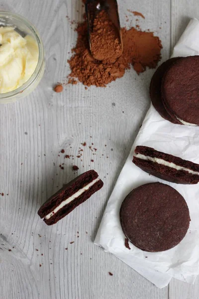 Galletas sándwich de chocolate con relleno de crema sobre fondo de madera — Foto de Stock