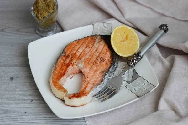 Salmón a la parrilla con salsa y limón sobre fondo de madera — Foto de Stock