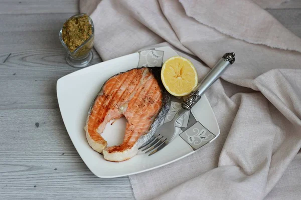 Salmón a la parrilla con salsa y limón sobre fondo de madera — Foto de Stock