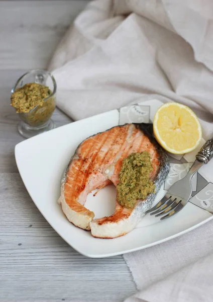 Salmón a la parrilla con salsa y limón sobre fondo de madera — Foto de Stock