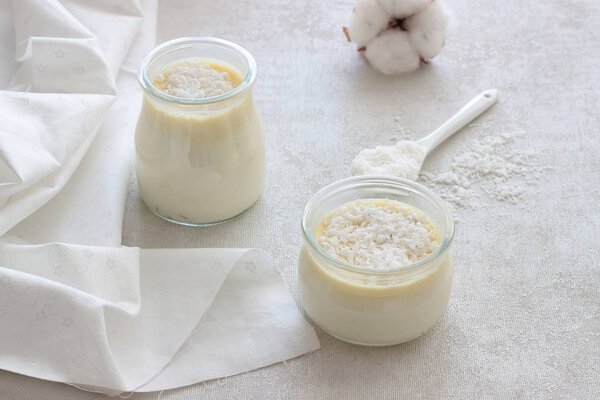 Панна Котта с белым шоколадом и кокосовыми чипсами на белом фоне
