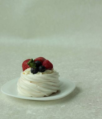 Pavlova beze pasta beyaz zemin üzerine taze çilek ile