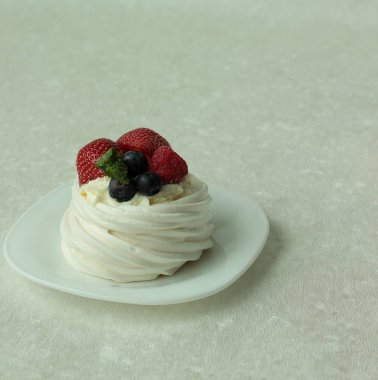 Pavlova beze pasta beyaz zemin üzerine taze çilek ile