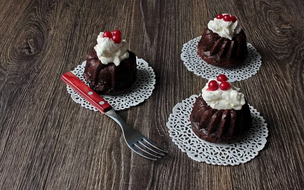 Çilek ve krema koyu ahşap arka plan üzerinde koyu çikolata muffins — Stok fotoğraf