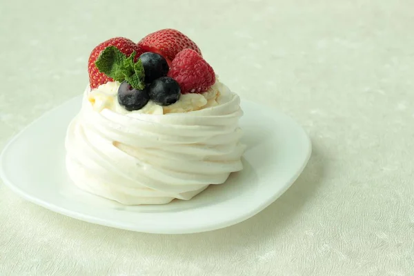 Kue meringue Pavlova dengan buah berry segar di latar belakang putih — Stok Foto