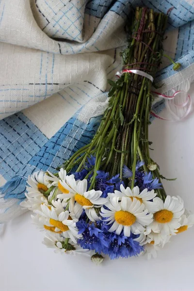 Schöner Strauß Kamillen und Kornblumen auf weißem Tisch — Stockfoto