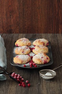 Kırmızı kuş üzümü ile kekler ile pudra şekeri serpilir. 