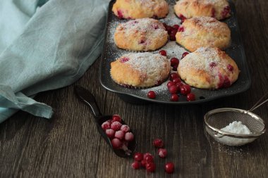 Kırmızı kuş üzümü ile kekler ile pudra şekeri serpilir. 
