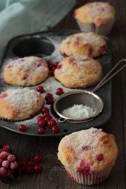 Kırmızı kuş üzümü ile kekler ile pudra şekeri serpilir. 