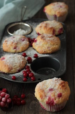 Kırmızı kuş üzümü ile kekler ile pudra şekeri serpilir. 