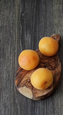 Olgun kayısı rustik ahşap bir masa üzerinde. Yazıt için bir yer