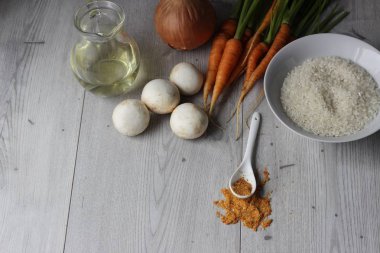 Malzemeler: pirinç, mantar, havuç ve soğan gri arka plan üzerinde. Kopya alanı