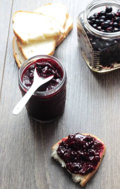 Siyah frenk üzümü reçeli ve ahşap masa ekmek. Metin için yer