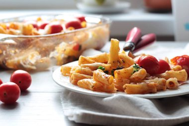 Kiraz domates, kabak ve bir tabak peynirli makarna penne. 