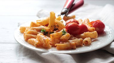 Kiraz domates, kabak ve bir tabak peynirli makarna penne. 