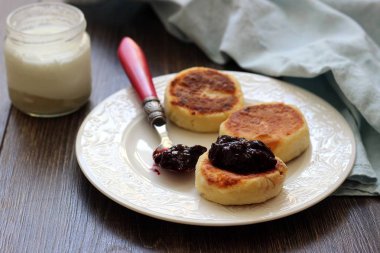 Süzme peynir tabakta reçelli krep. Syrniki. Geleneksel Rus Mutfağı