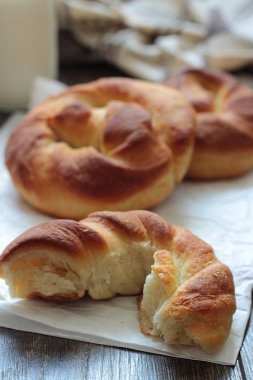 Ahşap masa üzerinde süt şişesiyle taze lezzetli ekmek.