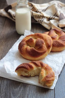 Ahşap masa üzerinde süt şişesiyle taze lezzetli ekmek.