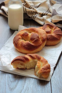 Ahşap masa üzerinde süt şişesiyle taze lezzetli ekmek.