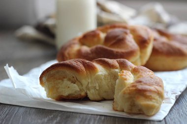 Ahşap masa üzerinde süt şişesiyle taze lezzetli ekmek.