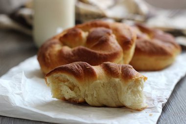 Ahşap masa üzerinde süt şişesiyle taze lezzetli ekmek.