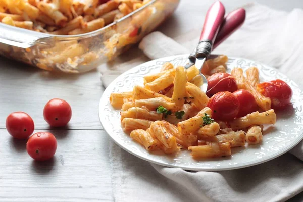 Kiraz domates, kabak ve bir tabak peynirli makarna penne. 