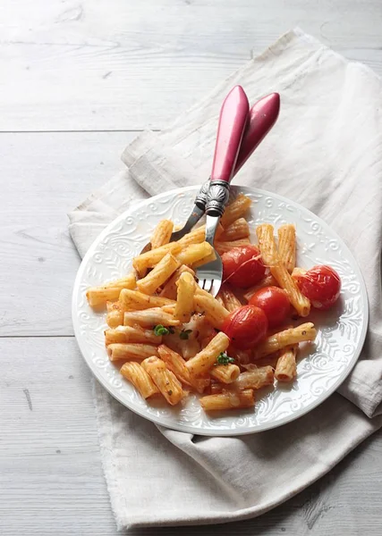 Kiraz domates, kabak ve bir tabak peynirli makarna penne. 