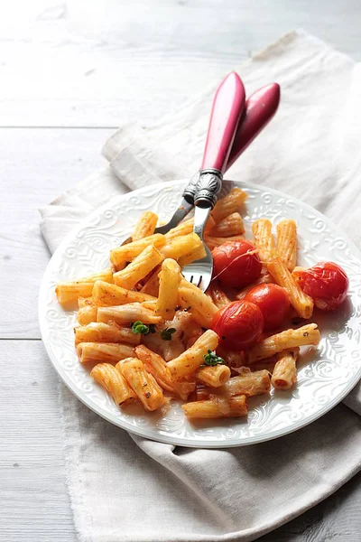 Kiraz domates, kabak ve bir tabak peynirli makarna penne. 