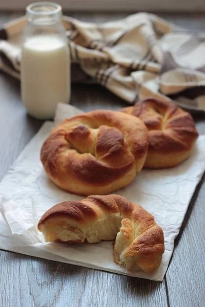 Ahşap masa üzerinde süt şişesiyle taze lezzetli ekmek.