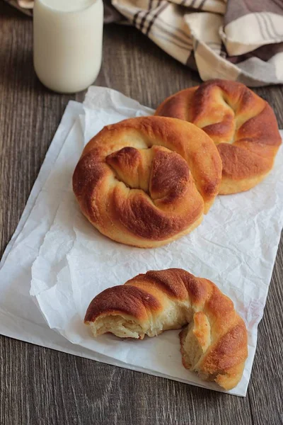 Ahşap masa üzerinde süt şişesiyle taze lezzetli ekmek.