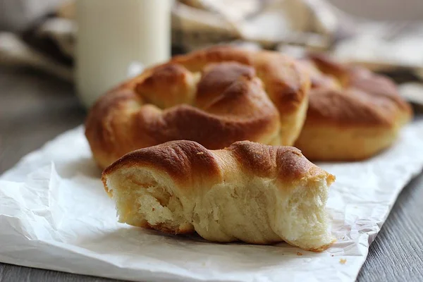 Ahşap masa üzerinde süt şişesiyle taze lezzetli ekmek.