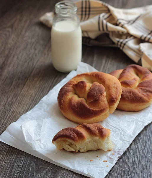 Ahşap masa üzerinde süt şişesiyle taze lezzetli ekmek.