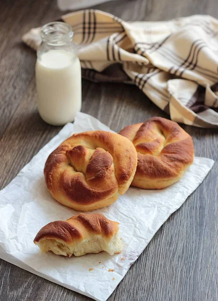 Ahşap masa üzerinde süt şişesiyle taze lezzetli ekmek.