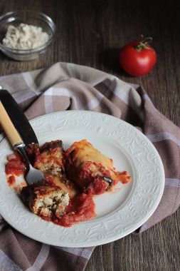 Ahşap bir masa üzerinde peynir Dolum ve domates soslu patlıcan böreği