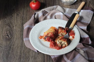 Ahşap bir masa üzerinde peynir Dolum ve domates soslu patlıcan böreği