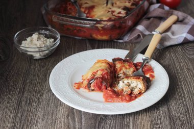 Ahşap bir masa üzerinde peynir Dolum ve domates soslu patlıcan böreği