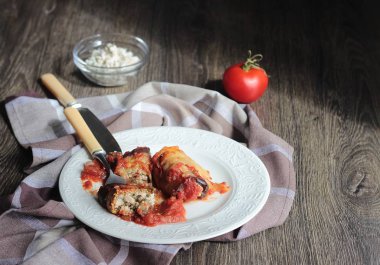 Ahşap bir masa üzerinde peynir Dolum ve domates soslu patlıcan böreği