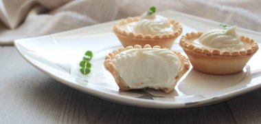 Tekstil ahşap gri doku zemin üzerine otlar ile antipasti tartlets yumuşak peynir Mus ile servis.