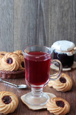 Ahşap bir masa üzerinde reçelli Kahvaltı, kırmızı çay çaydanlık ve bardak ve çerezleri için tablo hizmet